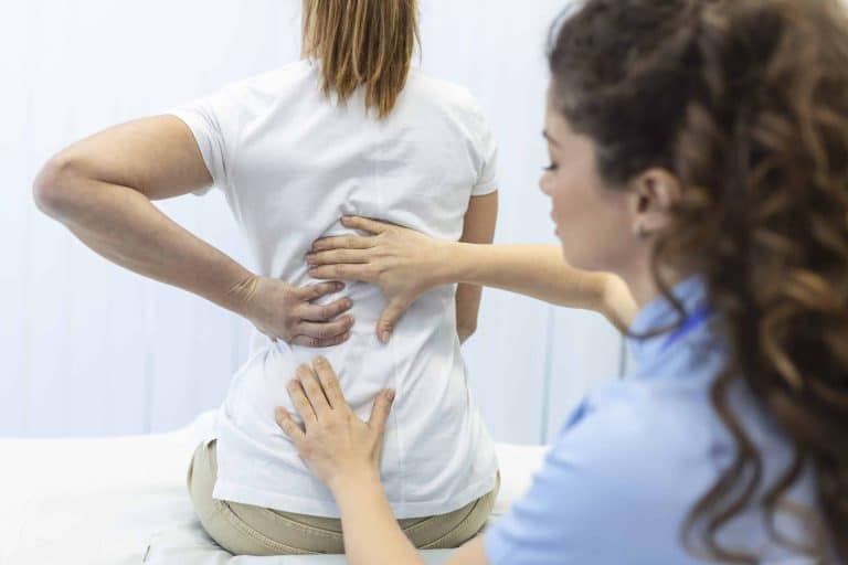Physiotherapist doing healing treatment on womans back. Back pain patient, treatment, medical doctor, massage therapist.offic